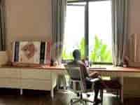 Kantor rumah dengan meja panjang, kursi, dan jendela dengan gorden.