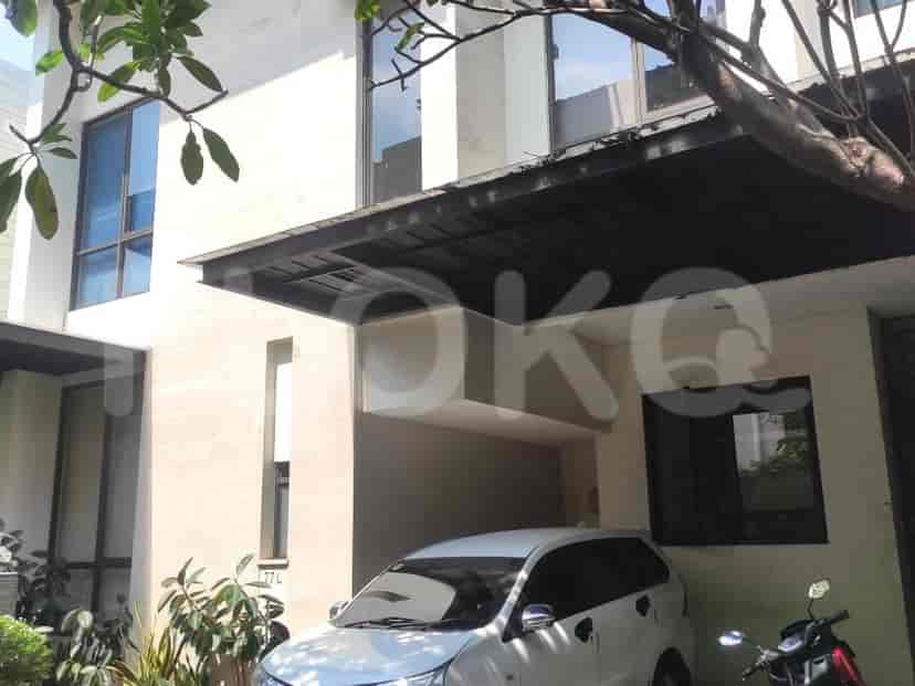 Rumah modern dengan carport dan sepeda motor yang diparkir di depannya.