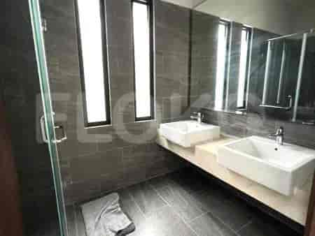 Kamar mandi modern dengan meja rias wastafel ganda, cermin besar, dan dinding berubin.