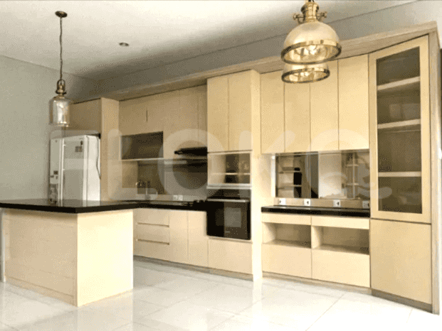 A modern kitchen with light-colored cabinetry, a black island with a breakfast bar, and pendant lighting.
