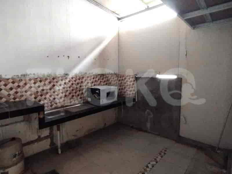 Dapur kecil dan sederhana dengan wastafel, microwave, dan backsplash berubin.