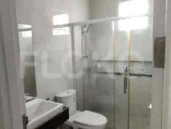 Kamar mandi modern dengan pancuran kaca, toilet, dan wastafel.