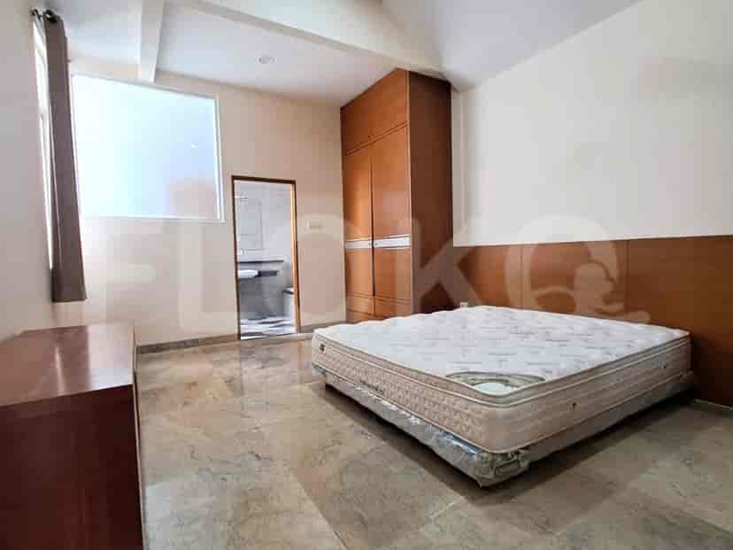 A bedroom with a queen-sized bed, wooden wardrobe, and a view of the ensuite bathroom.