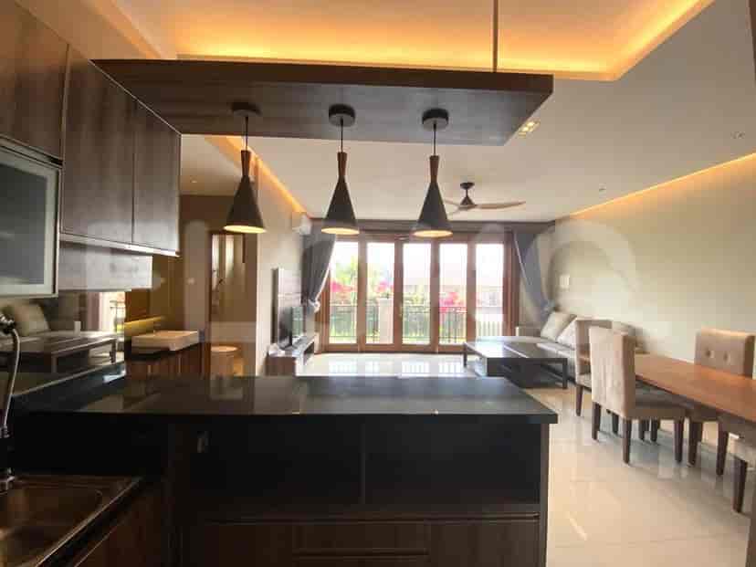 Ruang tamu yang luas dengan area makan, dan dapur terbuka, menampilkan akses ke balkon.