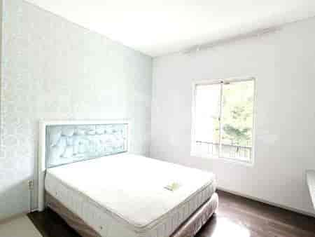 A bedroom with a queen-size bed, a floral wallpaper, and a large window with a balcony.