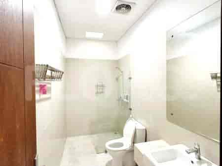 A modern bathroom with a glass shower enclosure, a white toilet, and a white sink.