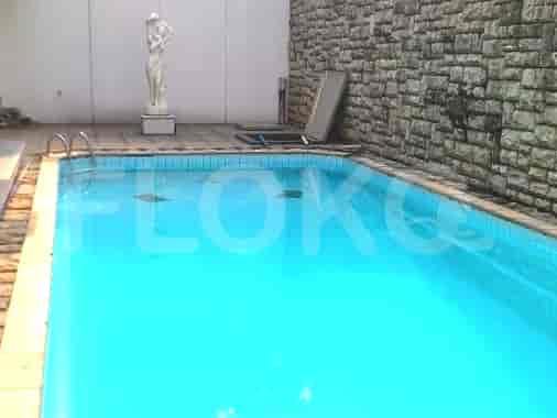 A swimming pool with a statue and a brick wall.