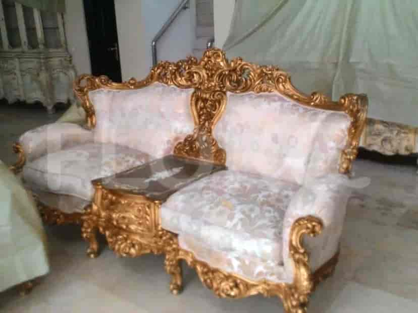 A living room with ornate sofas and a side table.