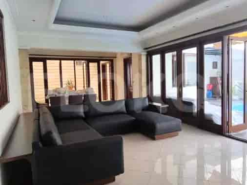A modern living room with a large sofa, and sliding doors to the outdoor area.