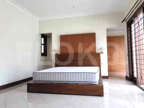 A bedroom with a bed, wardrobe, and large window.