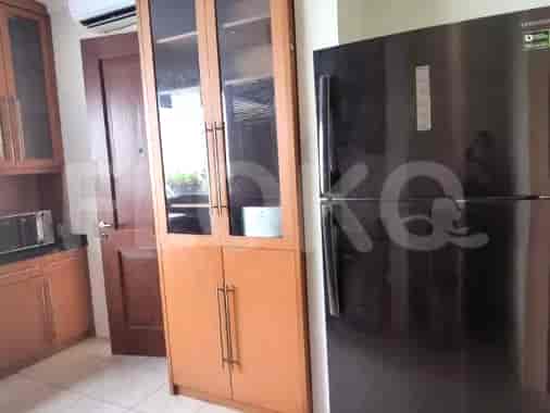 A kitchen with wooden cabinets, a refrigerator, and a microwave.