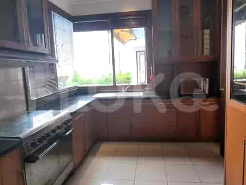 A kitchen with a gas stove, wooden cabinets, and a sink.