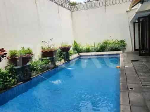 An outdoor area with a swimming pool, plants, and trees.