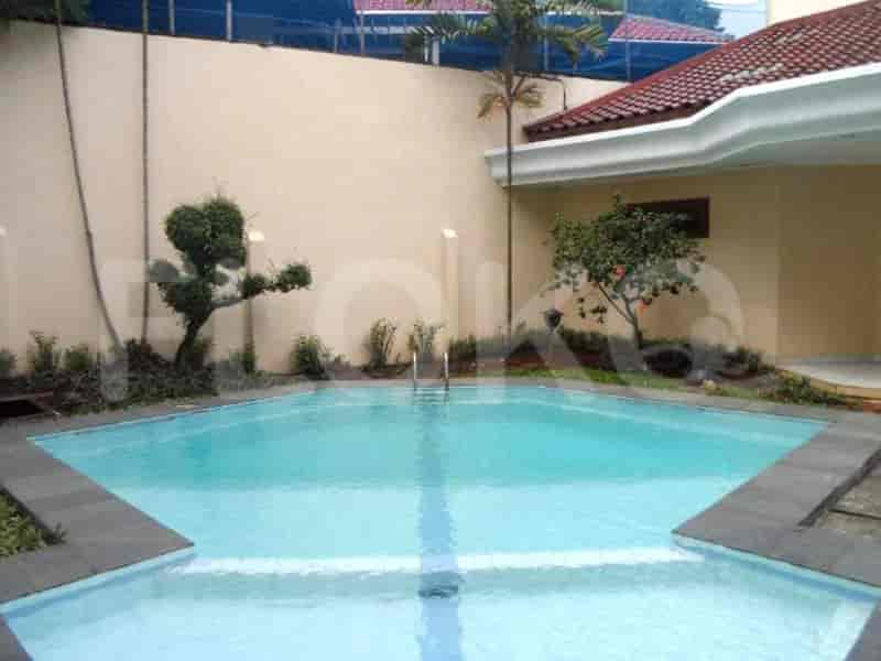 A beautiful swimming pool with clear water and tiled surroundings, surrounded by greenery.
