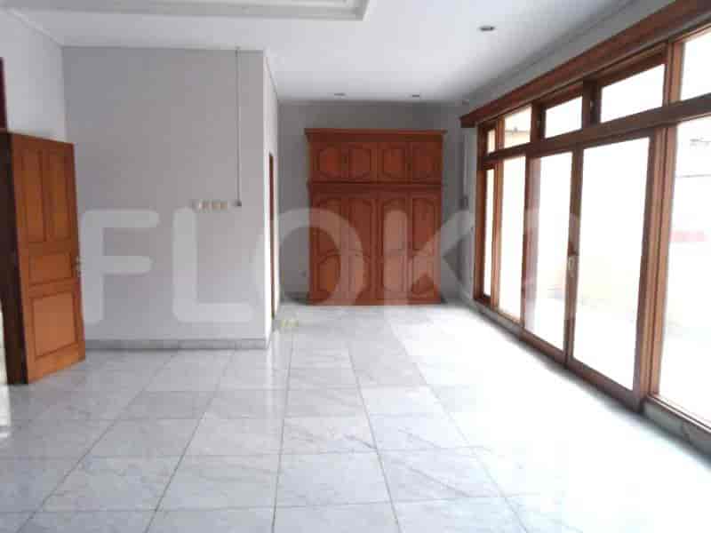 A living room with tile flooring, white walls, and a large wooden wardrobe.