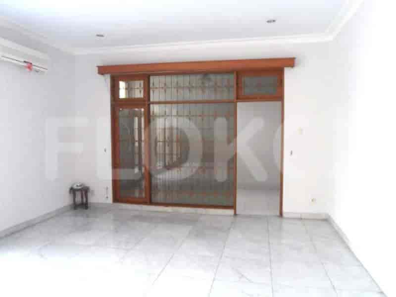A living room with white walls, tiled floor, and a sliding glass door.