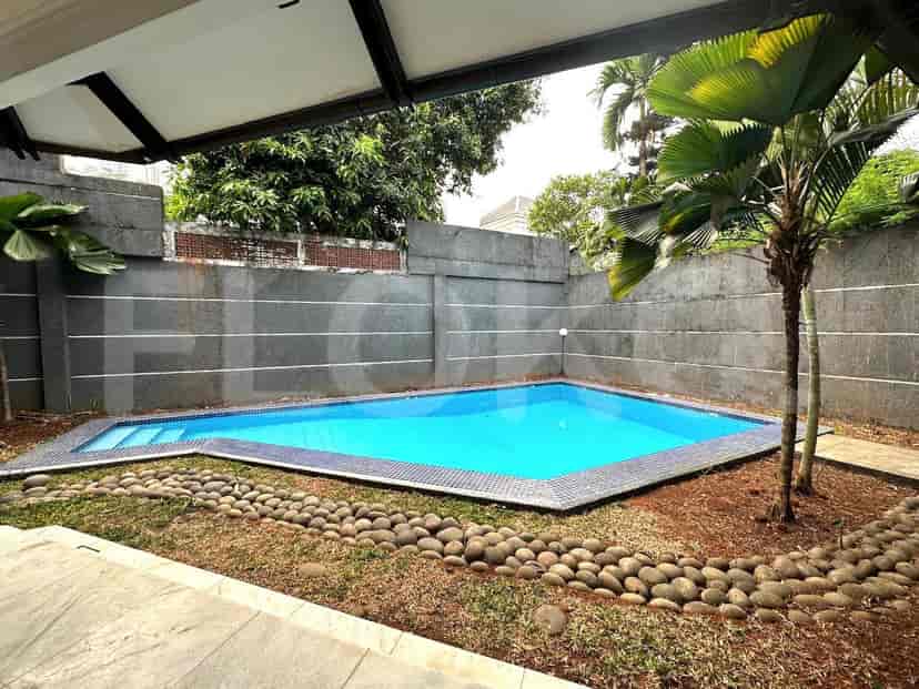 The exterior of the house features a swimming pool surrounded by a patio and palm trees.