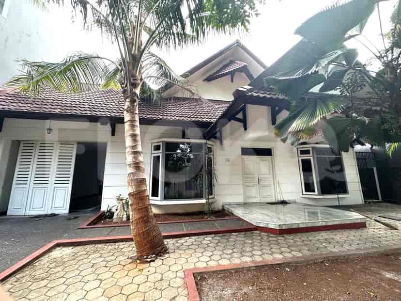 Exterior view of a white two-story house with a tiled roof, featuring a paved driveway and a palm tree.