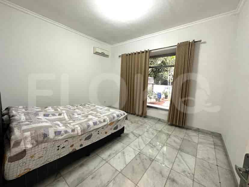 Bedroom with a bed, curtains and a window with outside view.