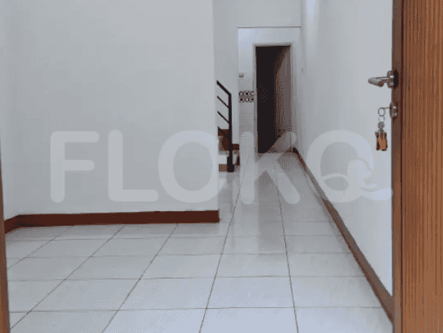An entryway with tiled floors, leading to a staircase and a hallway.