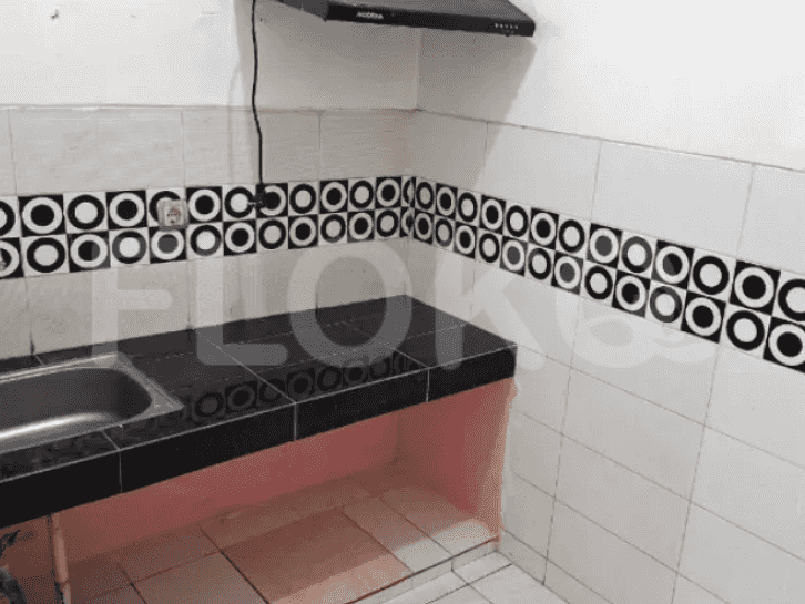 A small kitchen with a black countertop, and a sink.