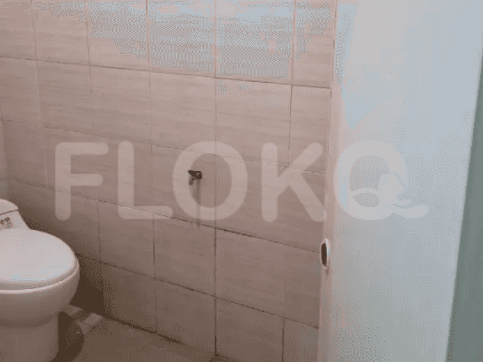 A bathroom with white walls, a toilet, and tiled floor.