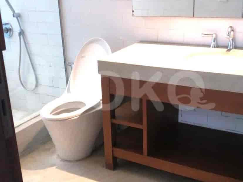 Kamar mandi dengan toilet dan meja rias modern, menampilkan desain minimalis.