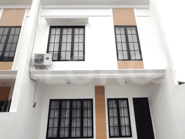A modern two-story townhouse with a white exterior, black-framed windows, and a small balcony.