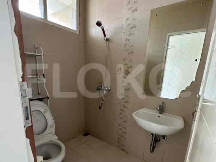 A bathroom with a toilet, sink, shower, and a mirror.