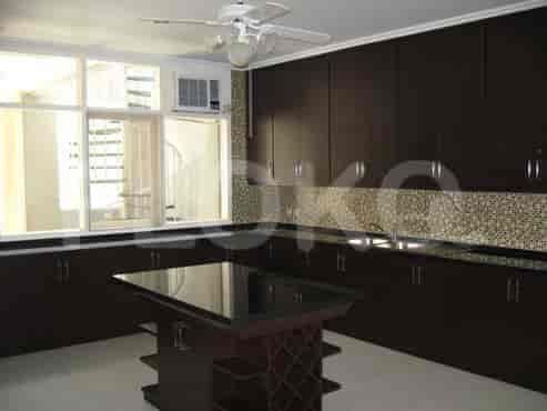 Dapur dengan lemari kayu gelap, pulau besar, dan pemandangan tangga spiral.