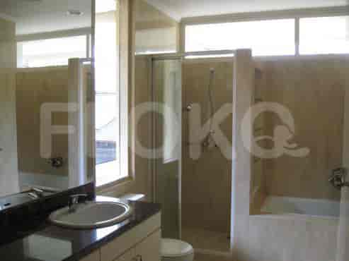 Kamar mandi yang menampilkan bak mandi berlapis marmer, shower, dan meja rias.