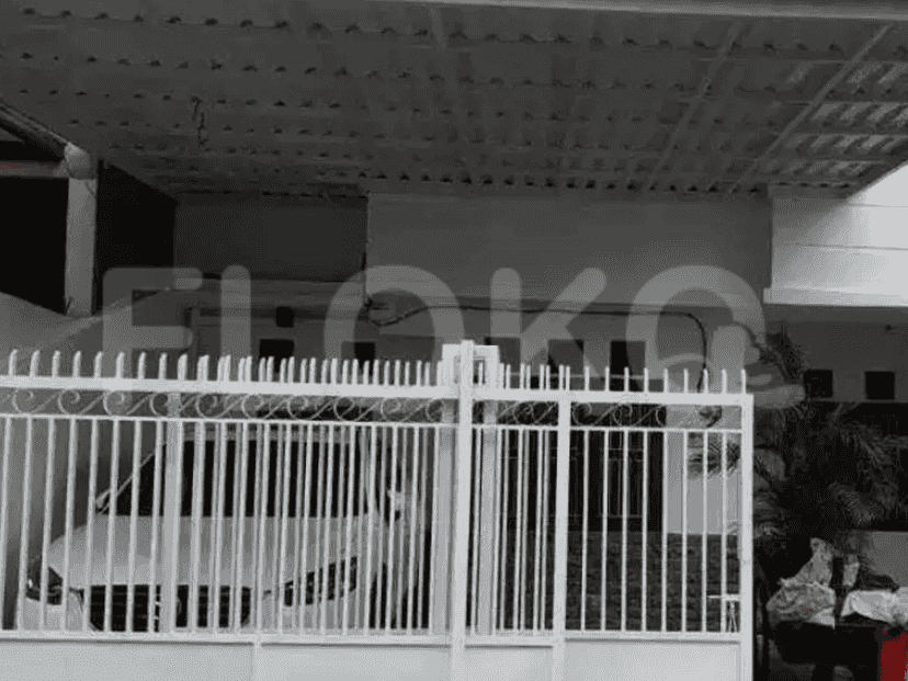 Eksterior rumah yang menampilkan gerbang putih, carport, dan pintu masuk beratap.