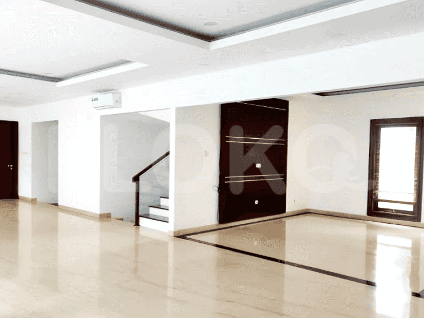 Sebuah foto interior yang menampilkan pintu masuk dan sebagian area ruang tamu dengan lantai marmer, dan tangga.