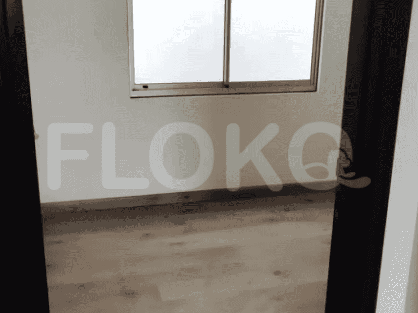 A view of the bedroom entrance with wooden flooring, looking toward the interior.