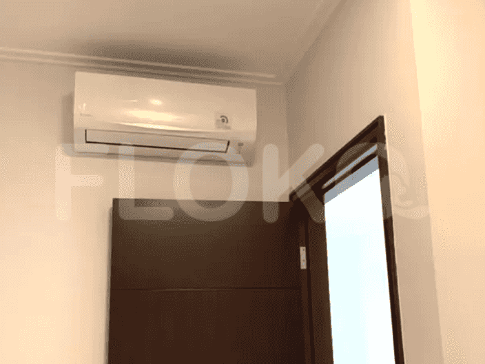 Unit AC dipasang di atas pintu di dalam ruangan.