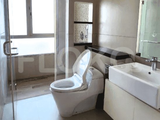 A modern bathroom with a Western-style toilet, a glass shower enclosure, and a vanity with a sink.