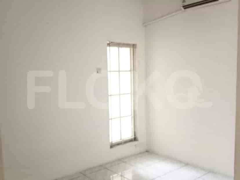 A small bedroom with a window, light-colored walls, and a simple design.