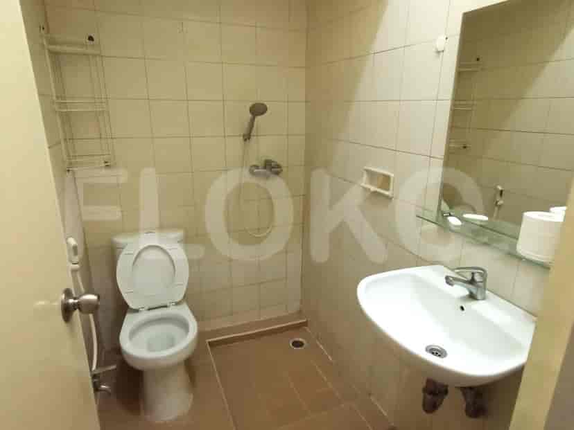 A simple bathroom setup with a toilet, a sink, and a shower.
