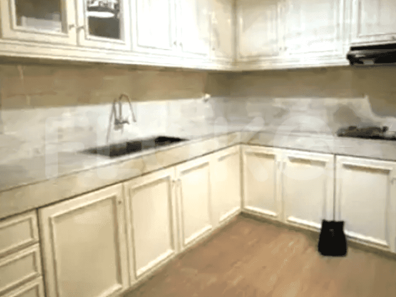 A kitchen with white cabinets and a marble countertop.