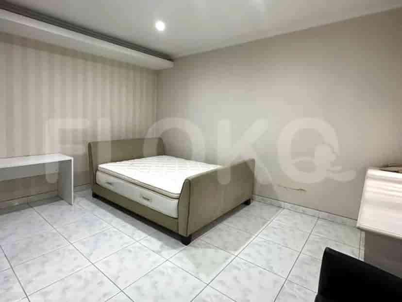 A bedroom featuring a double bed, desk, and tiled floors.