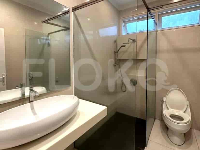 A modern bathroom with a glass-enclosed shower, vanity, and toilet.