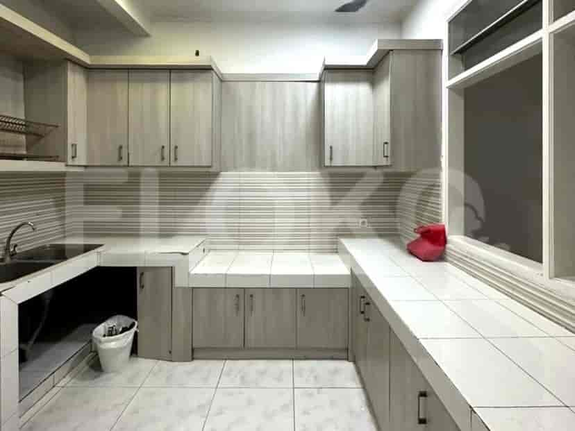 A kitchen with light-colored cabinets, countertops, and a sink.