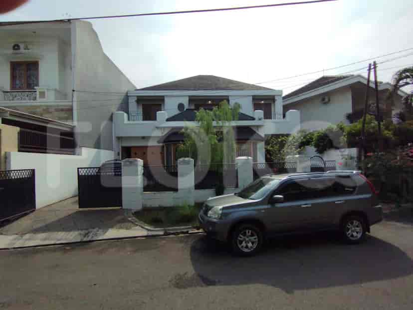 A house with white facade, car parked in front.