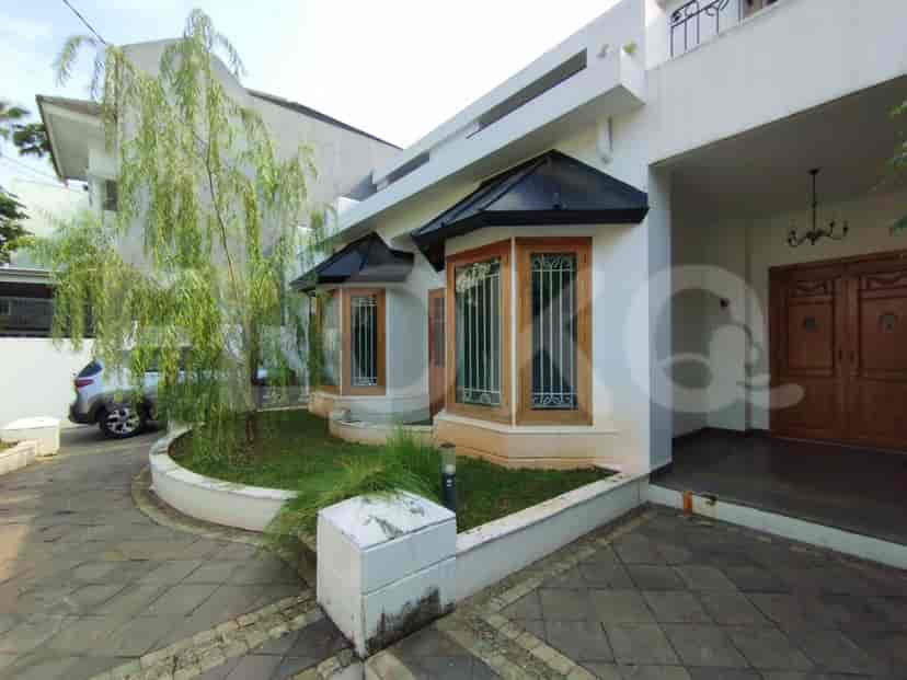 Exterior view of the house, showing the entrance, trees and the garage.