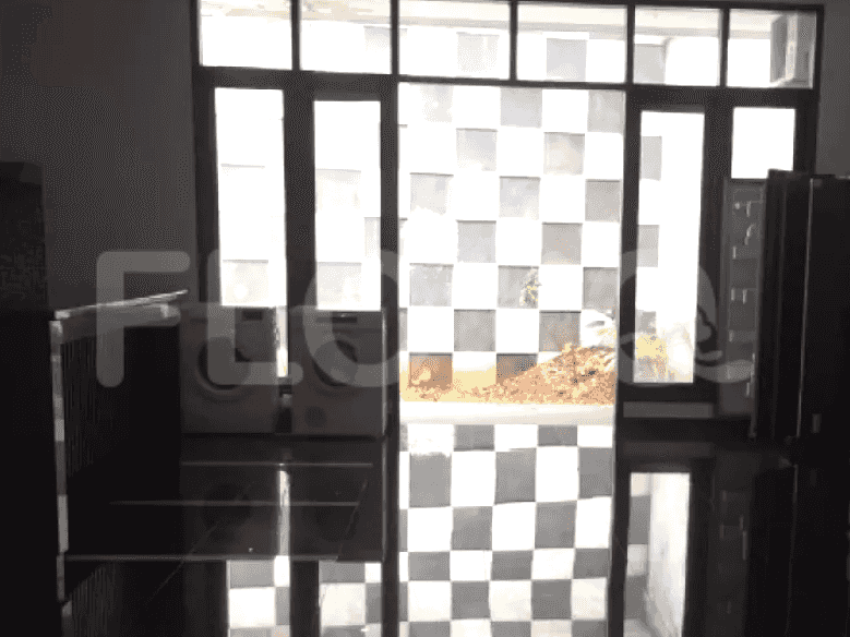 View of a doorway and windows, with a reflective tiled floor, leading to an outdoor area.