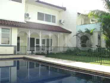 An outdoor view featuring a swimming pool, garden, and seating area.