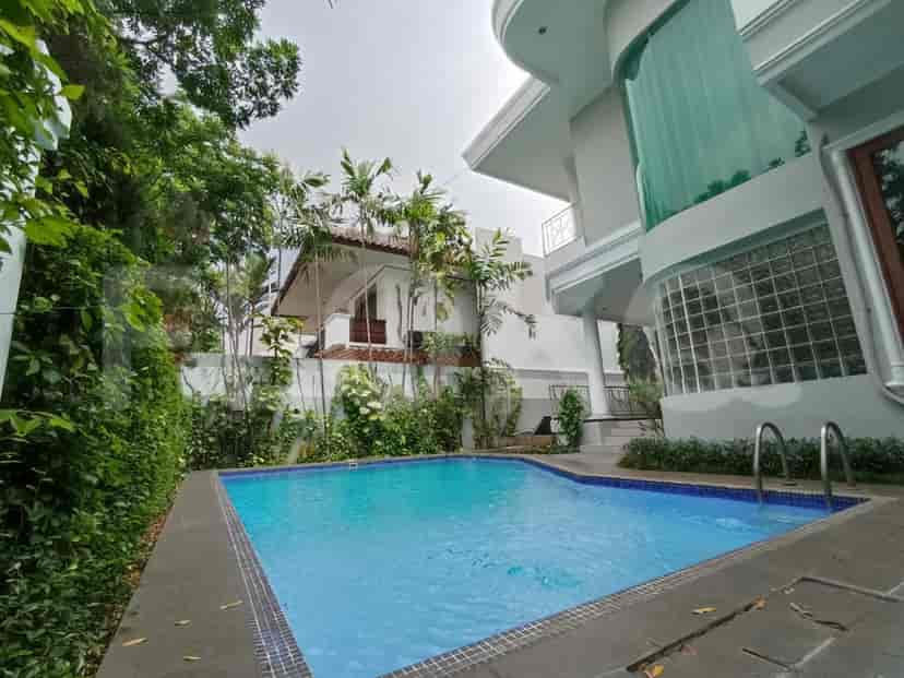 A swimming pool surrounded by trees and greenery.