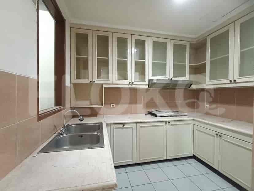 A kitchen with white cabinets, marble countertops, and a stainless steel sink.