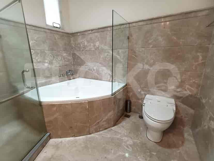 A bathroom with a corner bathtub, a toilet, and a glass shower enclosure.