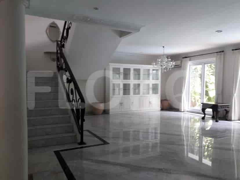 Another view of the living room with a staircase, showing more of the marble flooring.